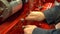 A worker in an assembly shop screws a nut with a wrench on an engine from a heavy tractor, close-up, selective focus.