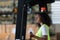 Worker in auto parts warehouse use a forklift to work to bring the box of auto parts into the storage shelf