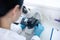 Worker of biochemical laboratory looking into optical tube of microscope