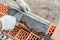 Worker or bricklayer works with trowel laying bricks. Builder makes brickwork on construction site, close up on hands