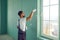 Worker builder plasterer plastering a wall of drywall at a construction site indoors