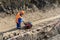 Worker is building a trench sand stone earth