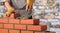 Worker builds a brick wall in the house