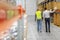 worker and businessman walking along warehouse