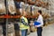 Worker and businessmen with clipboard at warehouse