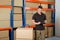 Worker With Cardboard Boxes Writing On Clipboard