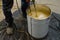 The worker is carefully mixing epoxy composites in a metal bucket to create high-quality polyurethane resin. This process requires