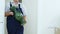 Worker carries green vintage vase along room with boxes