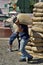 Worker carries heavy sacks of coffee beans