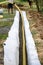 A worker carries a yellow perforated drainage pipe. Groundwater drainage works in the field