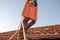 Worker carrying roof tile at the rooftop