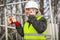 Worker with cell phone and adjustable wrench near fence