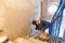 Worker is cementing by the putty knife the wall in room that is under construction, remodeling, renovation, extension