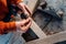 Worker changes a drill in a screwdriver, against the background of a wooden table