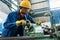 Worker checking quality behind an industrial machine