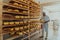 A worker at a cheese factory sorting freshly processed cheese on drying shelves