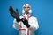 Worker in a chemical protective suit puts on gloves on a blue isolated background