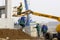 Worker on cherry picker in construction site