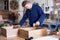 Worker chiseling plank at workshop