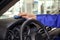 Worker cleaning automobile dashboard with rag at car wash