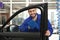 Worker cleaning automobile window glass with rag