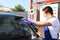 Worker cleaning automobile windshield