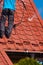 Worker cleaning metal roof with high pressure water