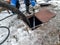 Worker cleaning the septic tank with water after emptying by sewage cleaner machinery