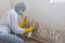 Worker of cleaning service using using spray bottle with mold remediation chemicals and scrubbing brush