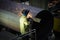 Worker cleans welded seam on steel pipe using grinding machine in metalwork workshop