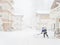 A worker clears snow among cottages on a foggy day during a blizzard