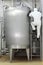 Worker climbing a ladder on industrial tank