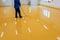 Worker, coating floor with self-leveling epoxy resin in industrial