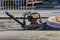 Worker compresses sand for paving slabs with special working tool - tamping machine or vibratory plate. Repair of pavement