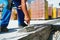 worker on construction site laying sealant for waterproofing concrete on construction site