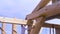 Worker at the construction site during the process of wooden house building on blue cloudy sky background. Clip. Men