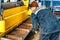 Worker cuts metal on mechanical guillotine machine in production hall. Industrial equipment for metal cutting.Real scene