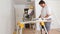 Worker cuts wood baseboard on the power miter saw