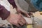 A worker cuts a wooden billet on a floor machine with a circular saw. Concept: woodworking, sawing of materials, violation of safe