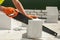 Worker cutting aerated block with a hand saw outdoor.