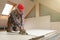 Worker cutting drywall plasterboard with construction knife. Attic renovation