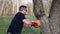 A worker dangerously cuts at a tree with chainsaw while under a large branch ALT2