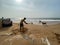 A worker digging sand on a beach to prevent coastal erosion due to rising sea levels at high