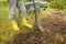 Worker digs the black soil with shovel in the vegetable garden, woman farmer loosens dirt in the farmland, agriculture