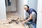 A worker dismantles the old parquet floor with a hammer and chisel. Renovation in the apartment