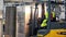 Worker distributing goods in a storehouse with forklift truck loader. Clip. Man driving a loading machine during the