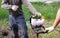 A worker is drilling soil for a gate on a fence