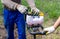 A worker is drilling soil for a gate on a fence