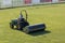 Worker Drives Lawn Equipment in Soccer Pitch before Match