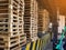 Worker driving forklift loading and unloading shipment carton boxes and goods on wooden pallet from container truck to warehouse c